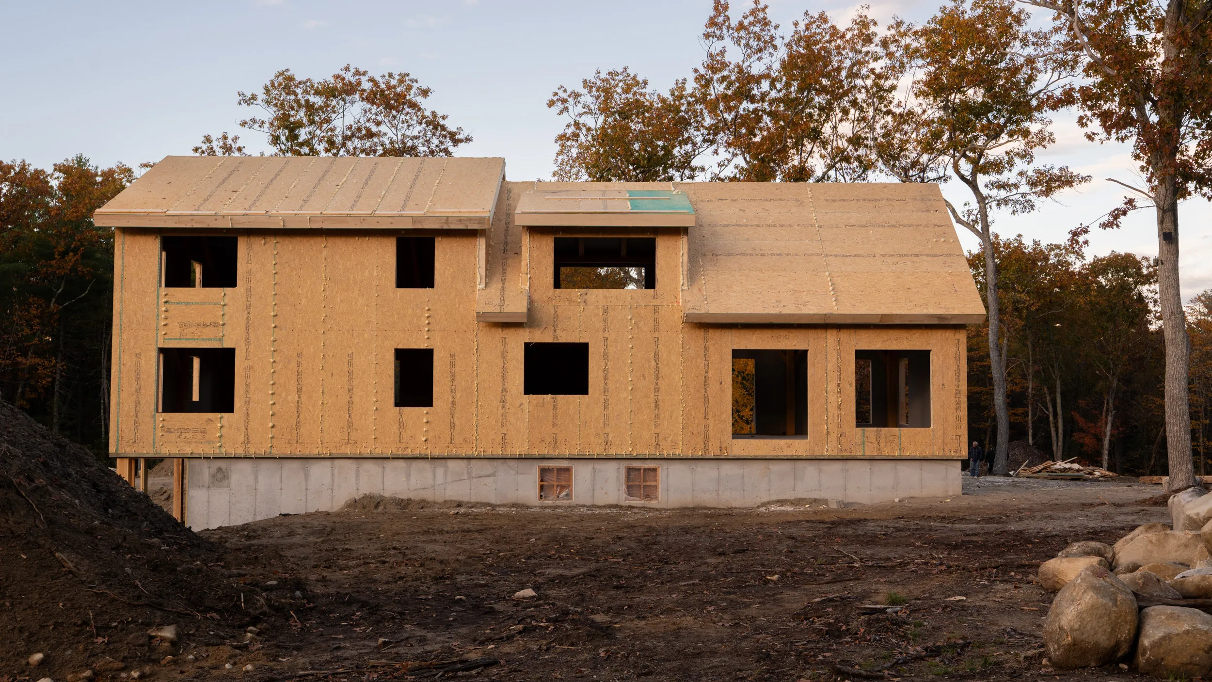 Wooden cabin under construction in a sunny forest clearing
