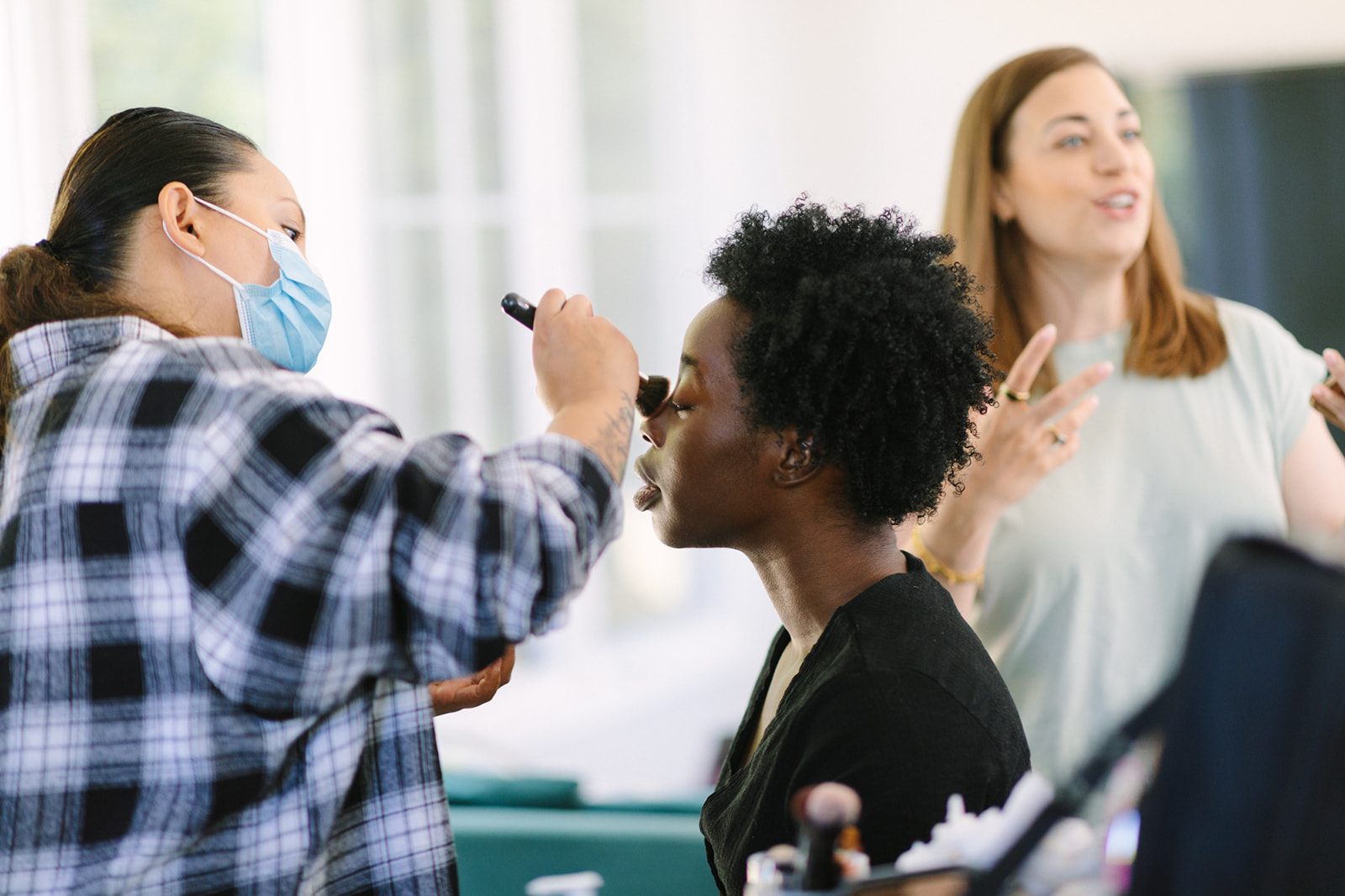 Make up artist applying make up to an actor on a video shoot