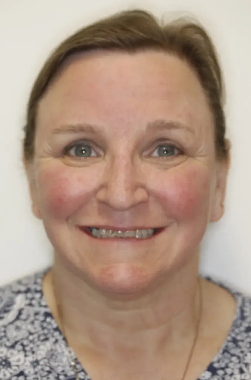 A woman with short hair smiles directly at the camera.