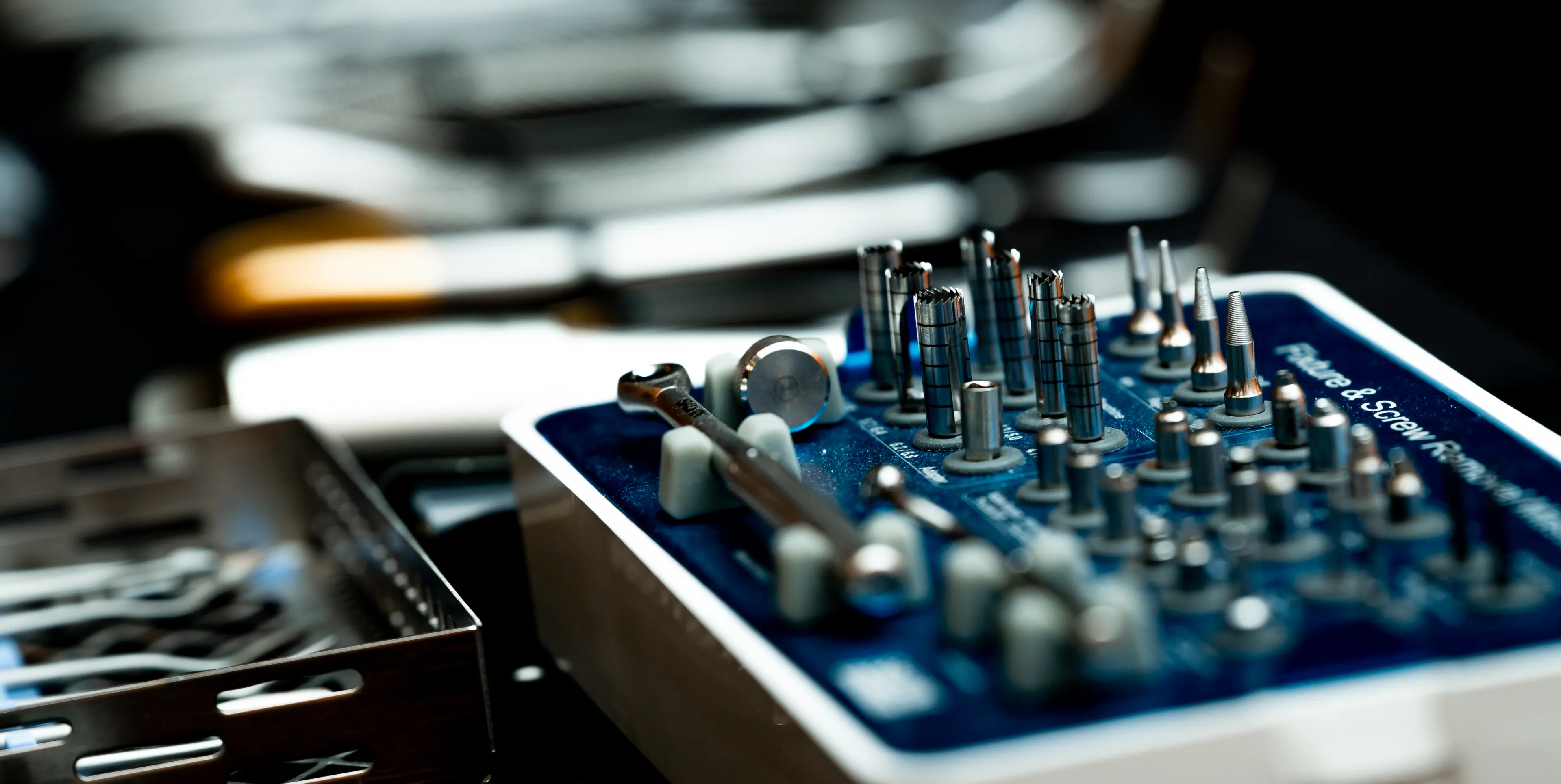 A set of dental drills organized in a blue and white holder on a table.