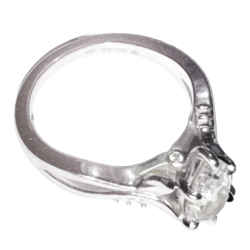 Close-up of a silver engagement ring with a round diamond solitaire set in a prong setting.