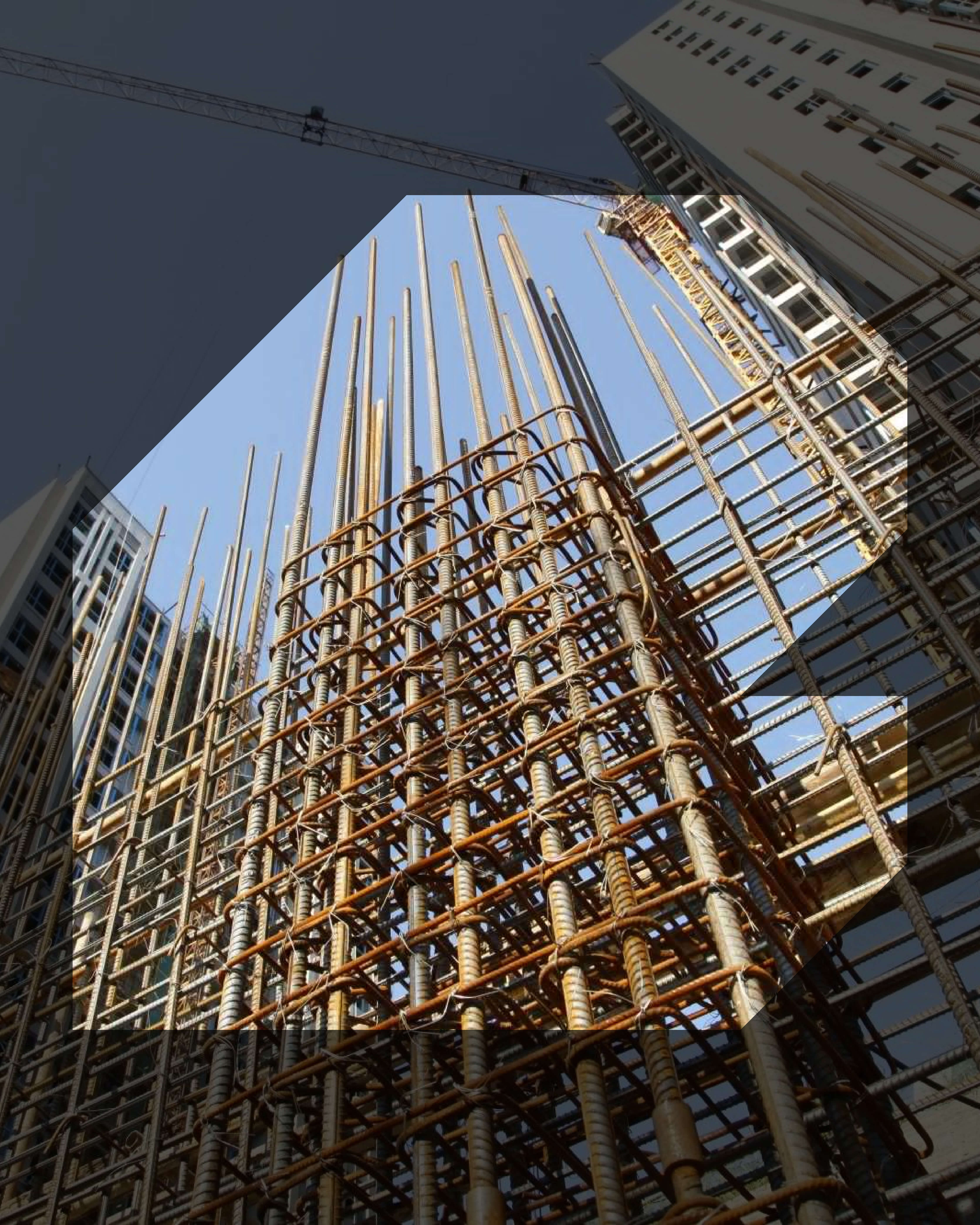 Reinforced steel bars forming the framework for a building's concrete structure under construction with cranes and tall buildings in the background.