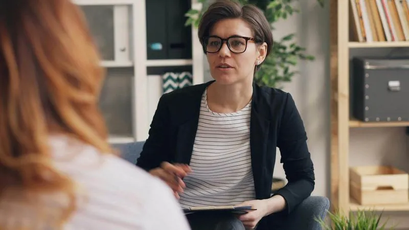 A woman wearing glasses and a black jacket.
