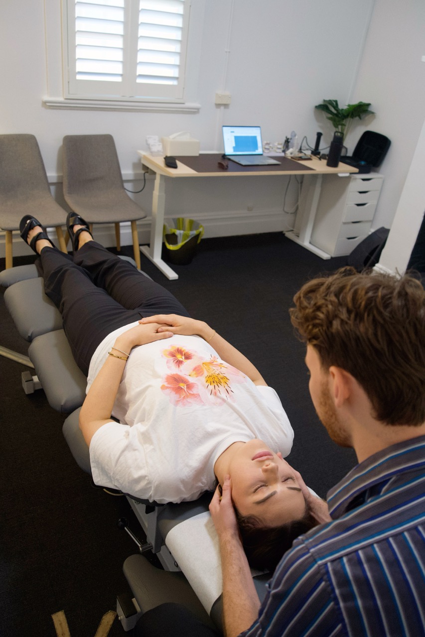 Chiropractor treating a patient on a chiropractic table.