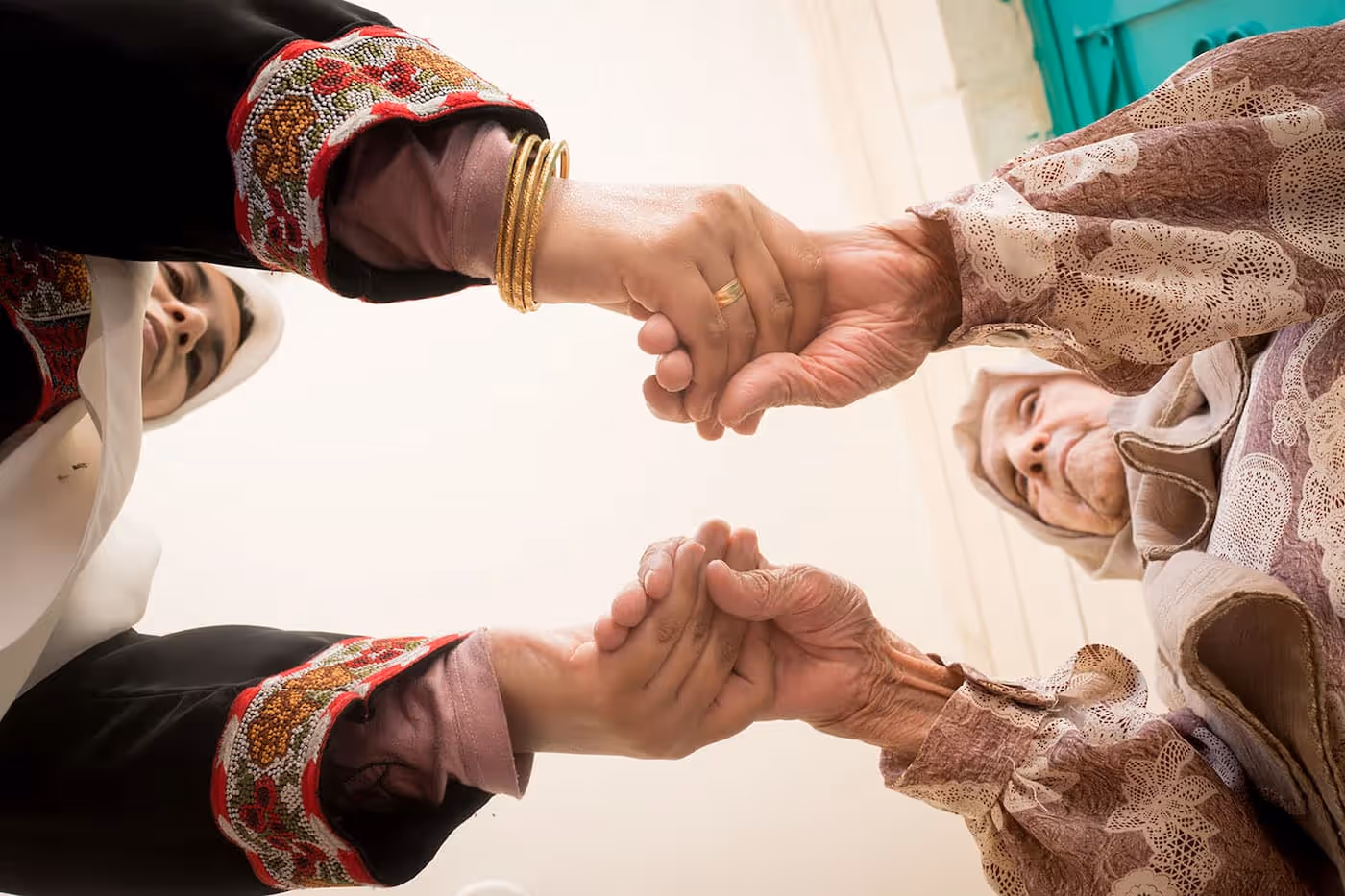 Muslim caregiver smiling beside a happy senior woman receiving in-home support.