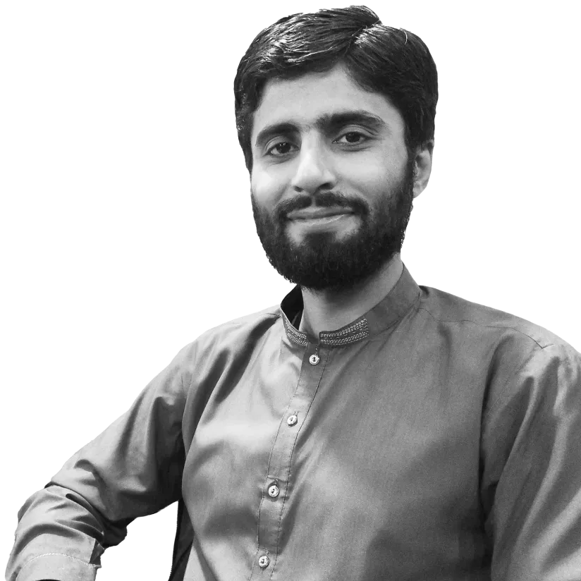 Smiling man with beard wearing a traditional buttoned shirt sitting with his arm resting.