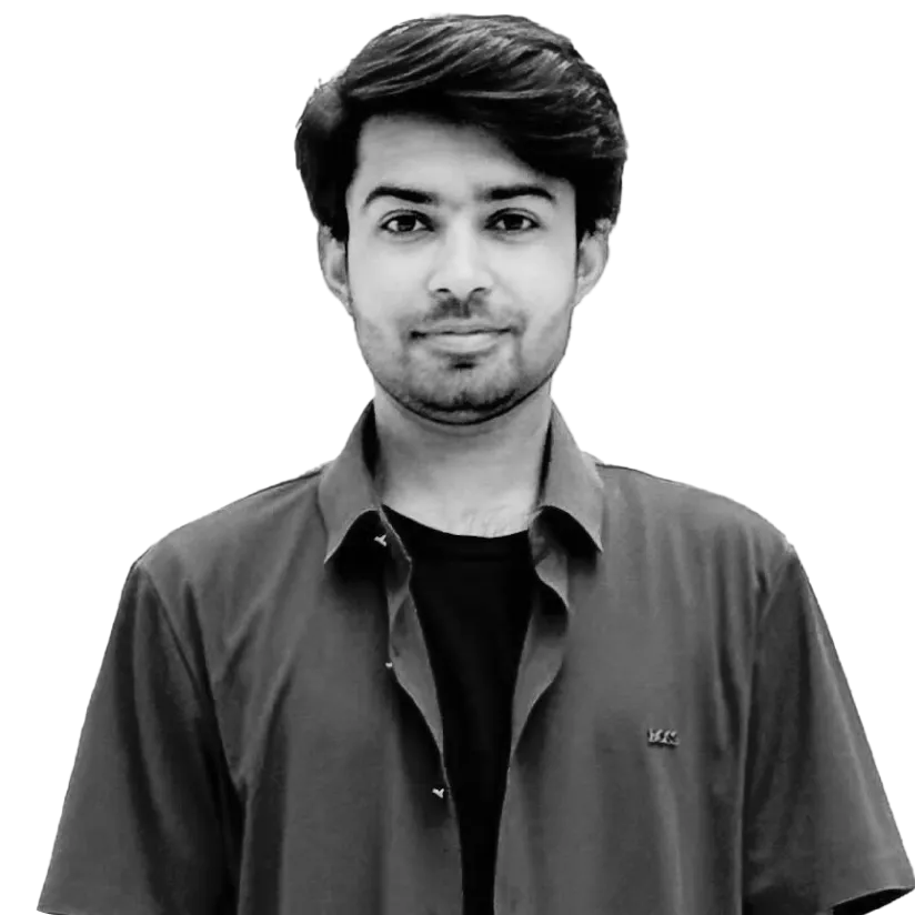 Portrait of a young man with dark hair wearing a dark shirt over a black t-shirt, smiling slightly.