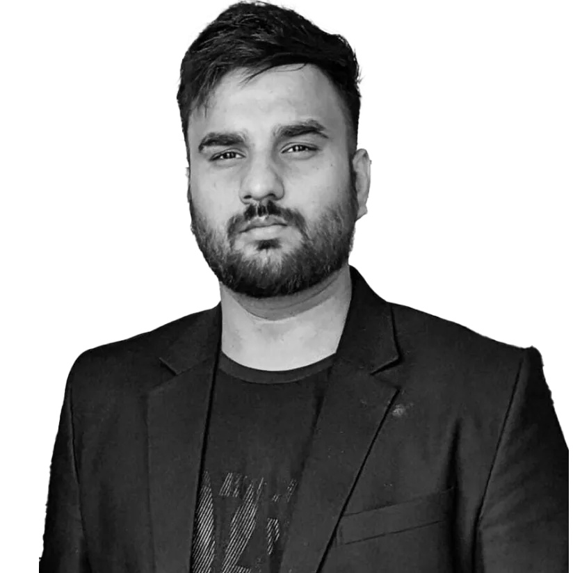 Portrait of a serious man with a beard wearing a black blazer and dark shirt.