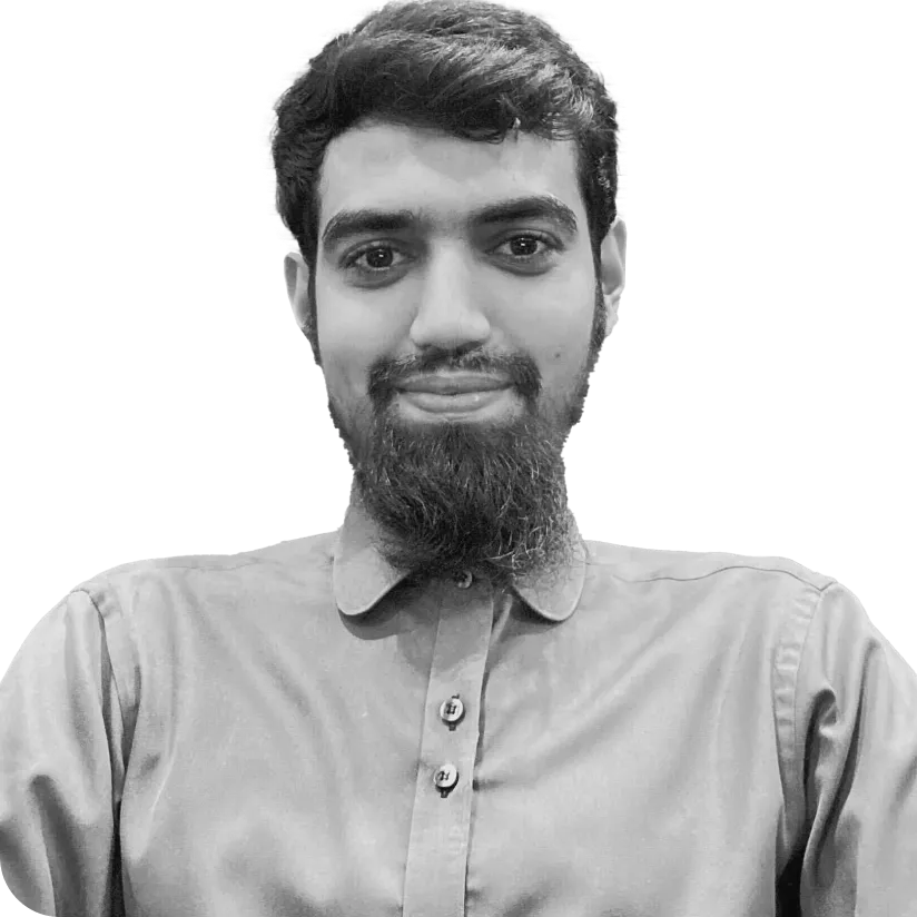 Portrait of a young man with a beard wearing a buttoned-up shirt, smiling slightly.