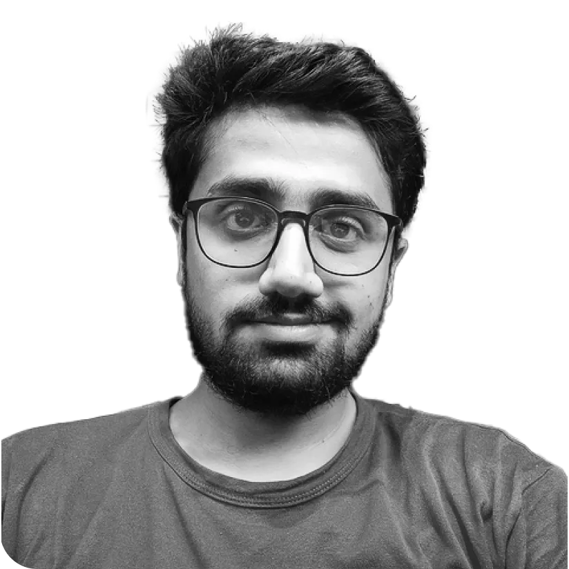 Young man with short dark hair, beard, and glasses wearing a t-shirt, looking at the camera.