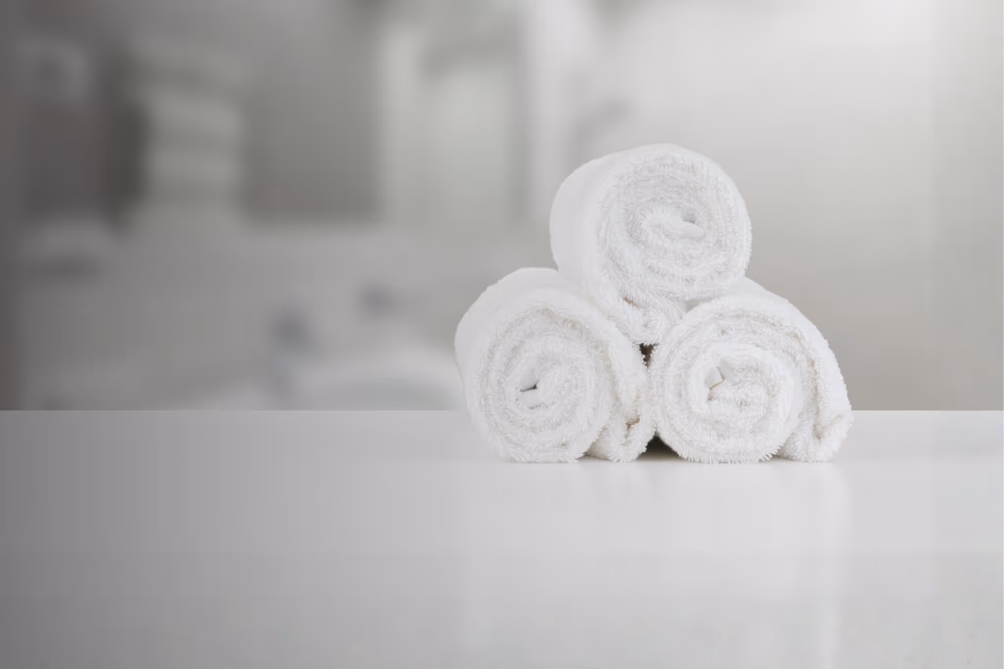 Nahaufnahme gerollter Handtücher im Bad.