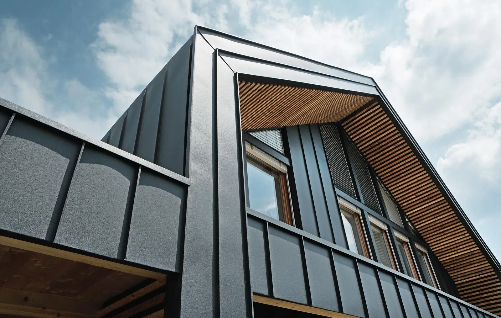 Modernes Haus mit Metallverkleidung und Holzgaube