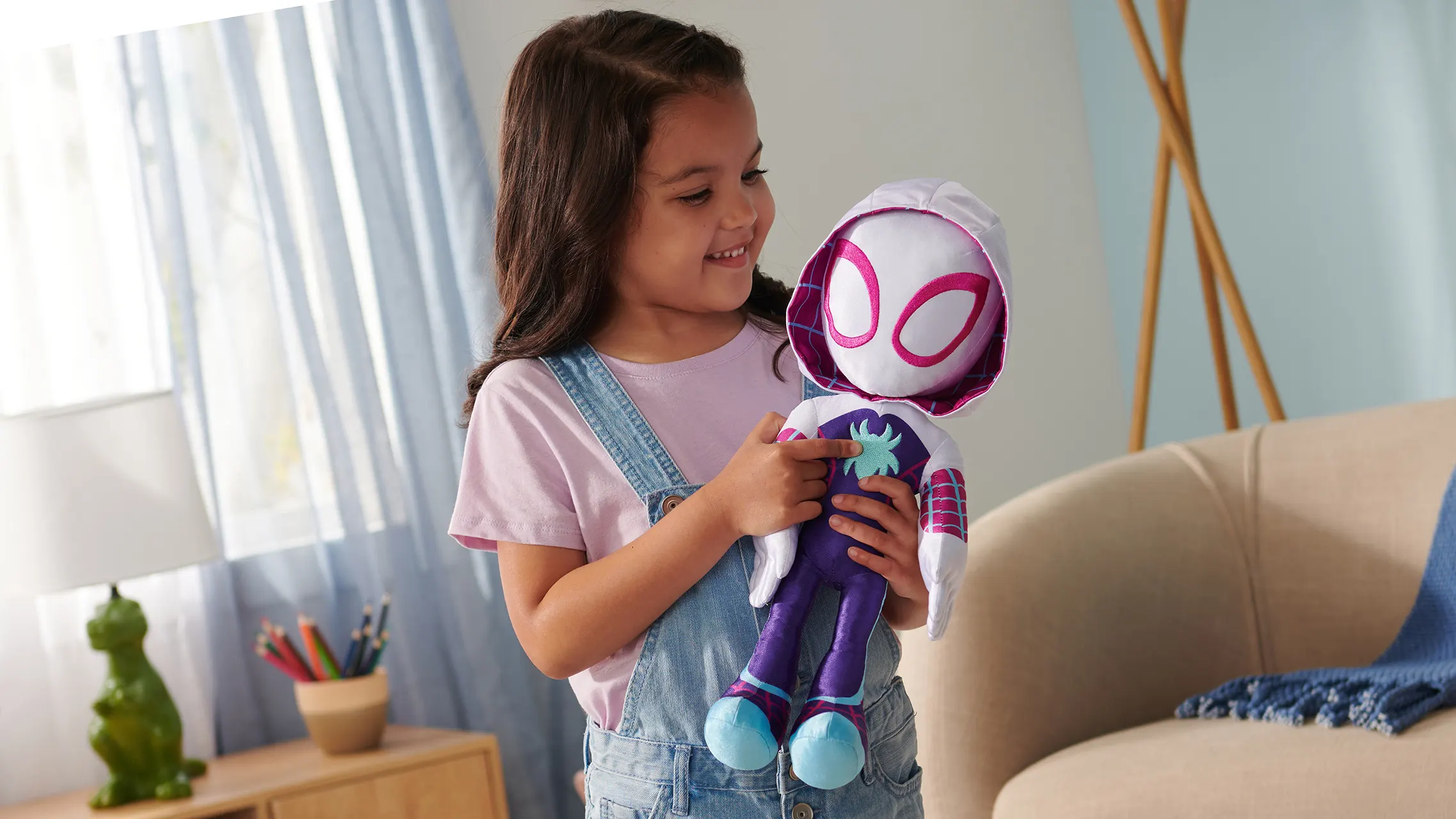 Girl holding a Ghost-Spider plush toy from Marvel Spidey and His Amazing Friends
