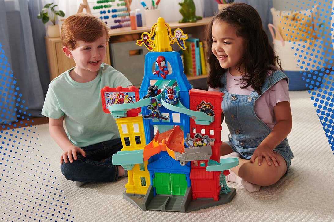 Two children playing with a Spidey and His Amazing Friends toy playset