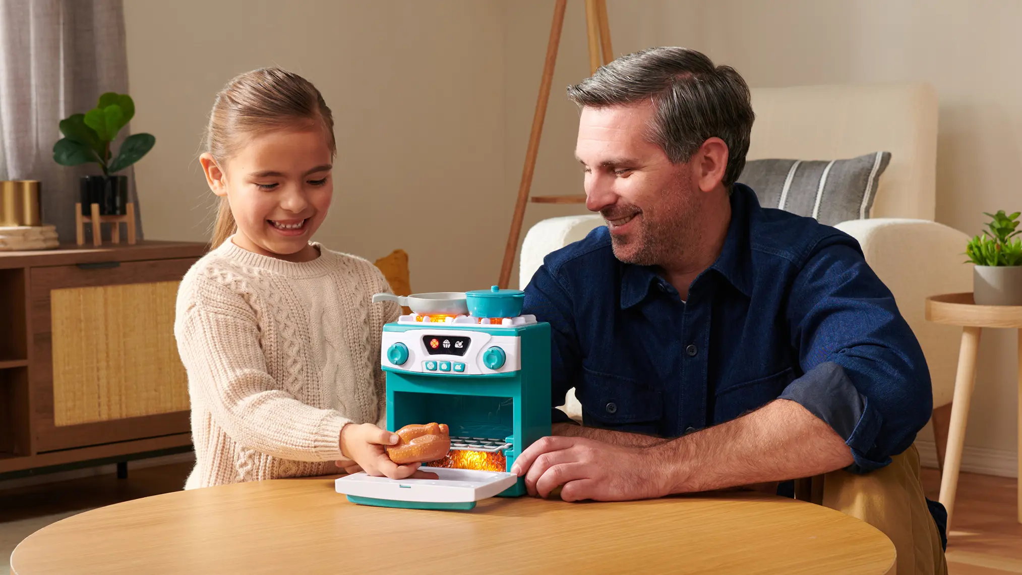 Father and daughter playing with a Black & Decker toy oven set