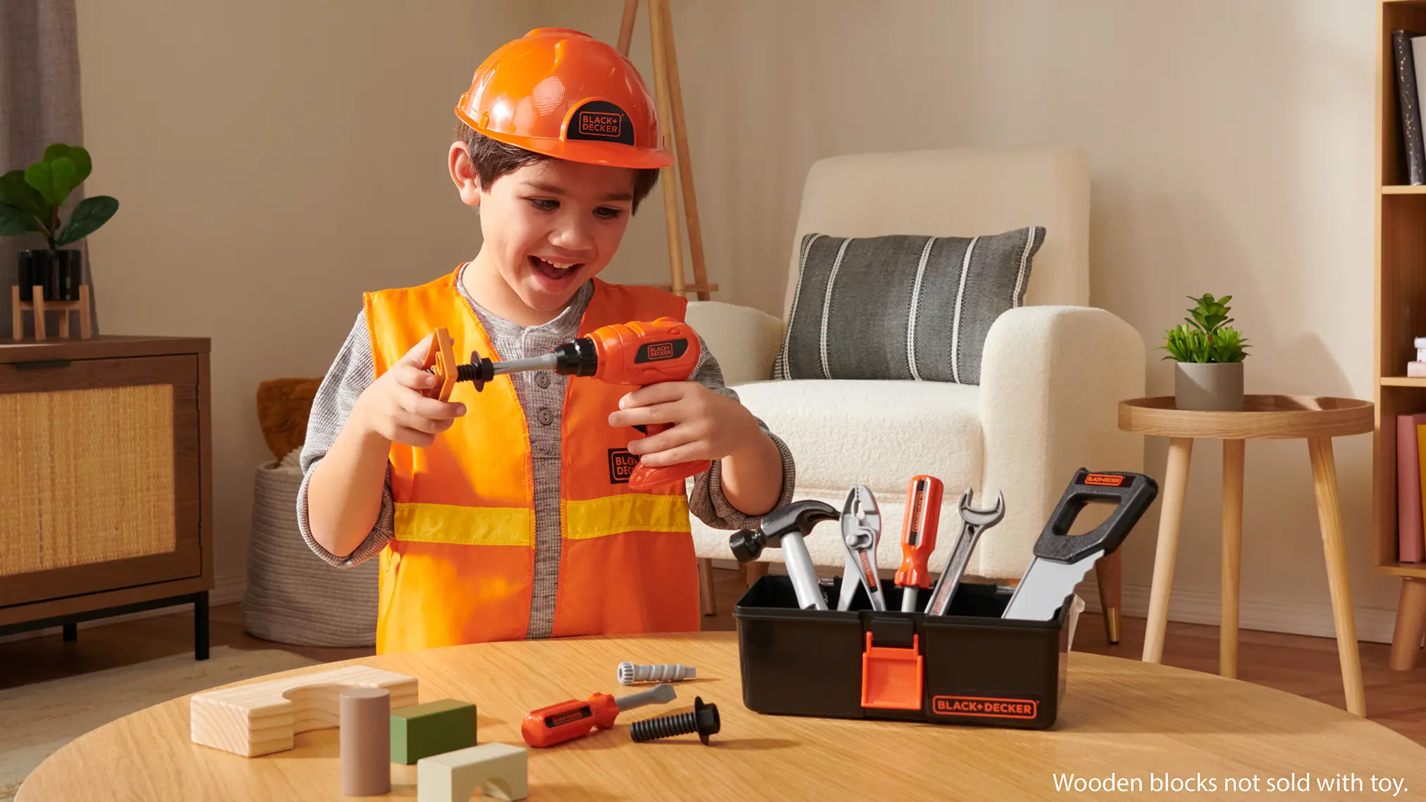 Child wearing a toy construction vest using a Black & Decker toy drill