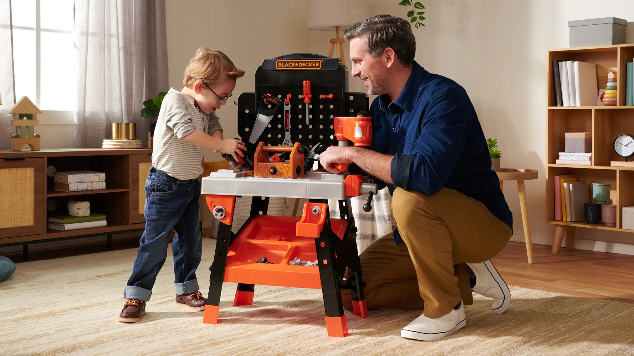 Father and child building together with a Black & Decker toy workbench