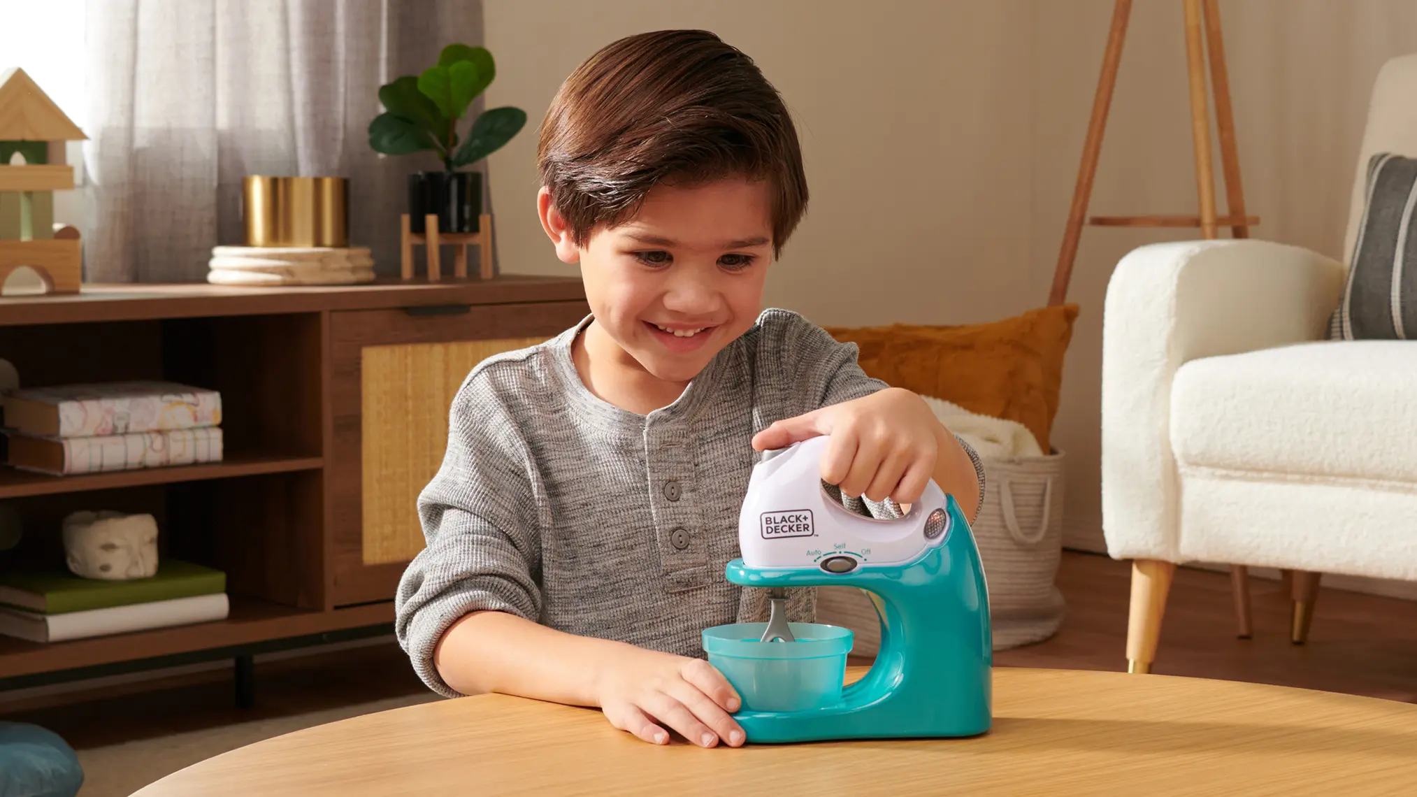 Child playing with a Black & Decker toy kitchen mixer