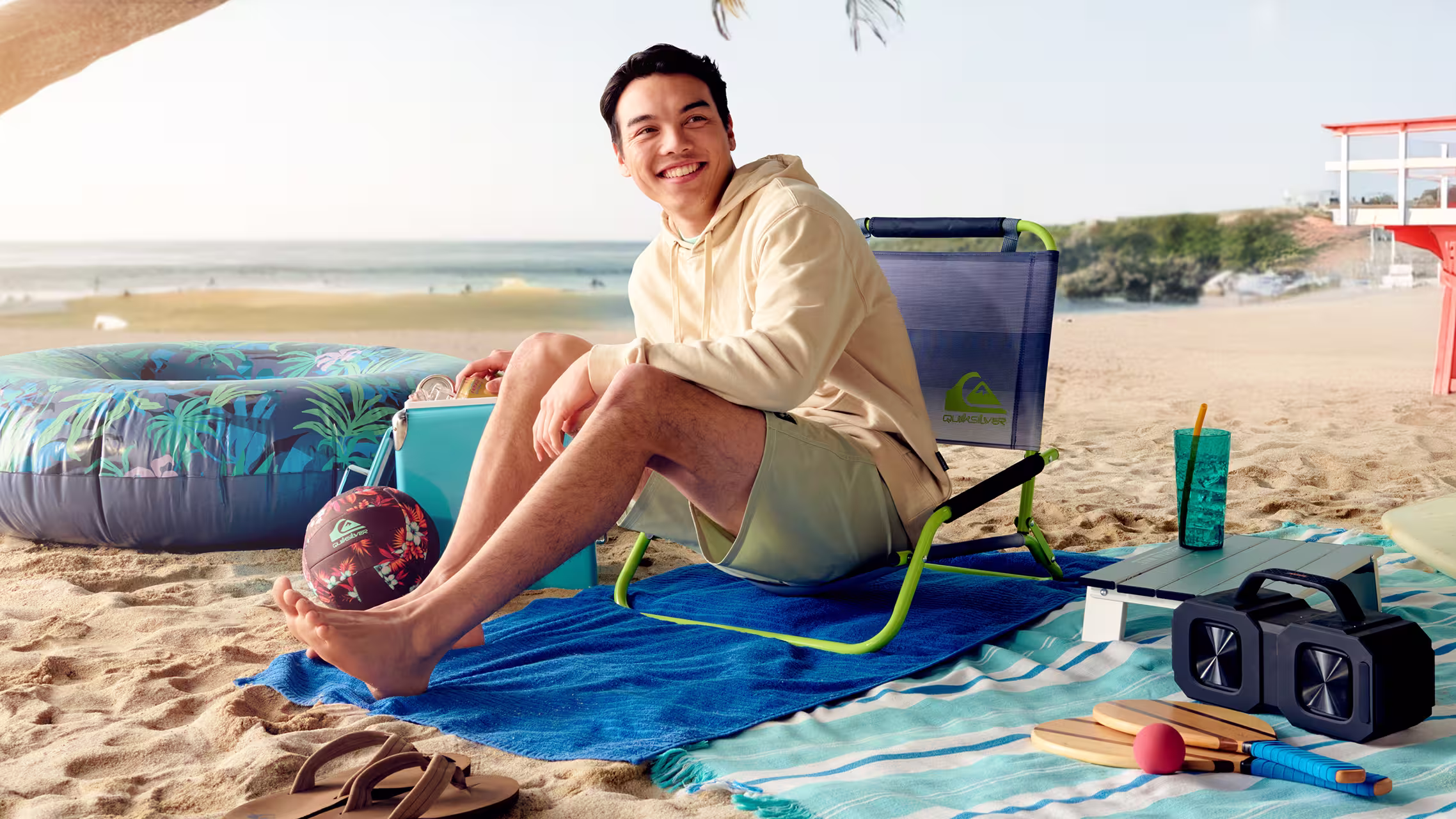 Man relaxing in a Quiksilver beach chair beside the ocean