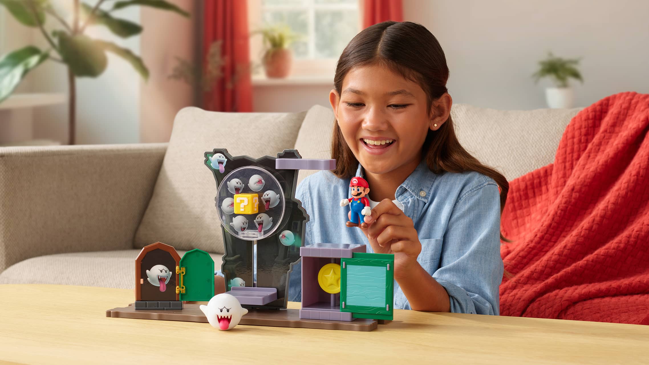 Child playing with Super Mario haunted house playset and Boo figures