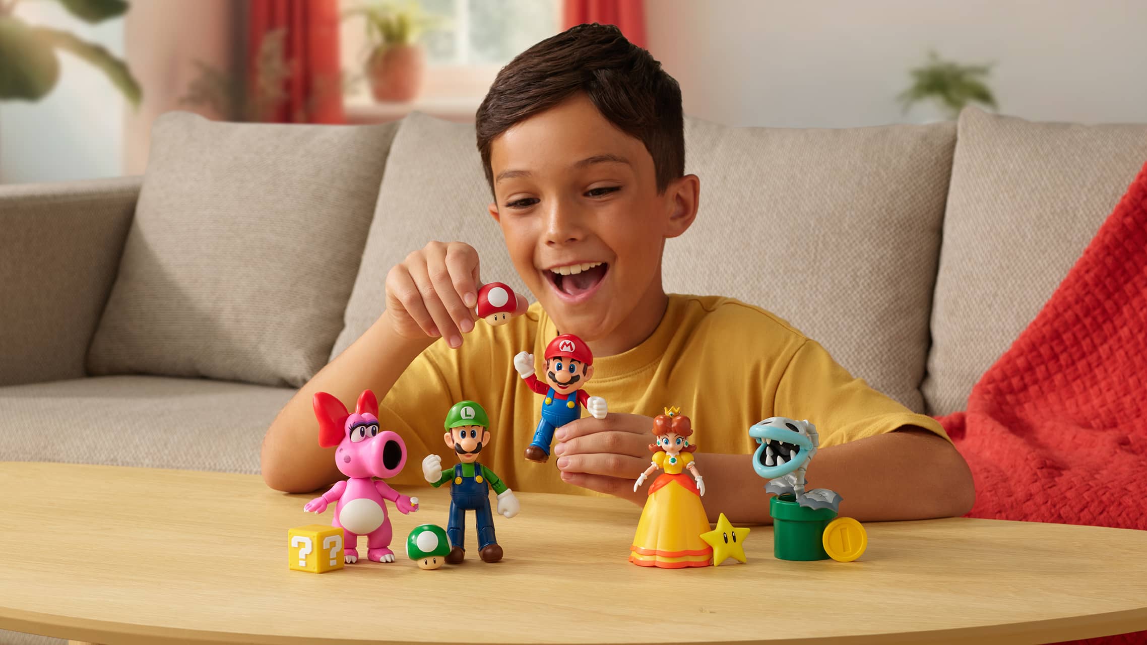 Child playing with Super Mario character figures including Mario, Luigi, and Princess Daisy