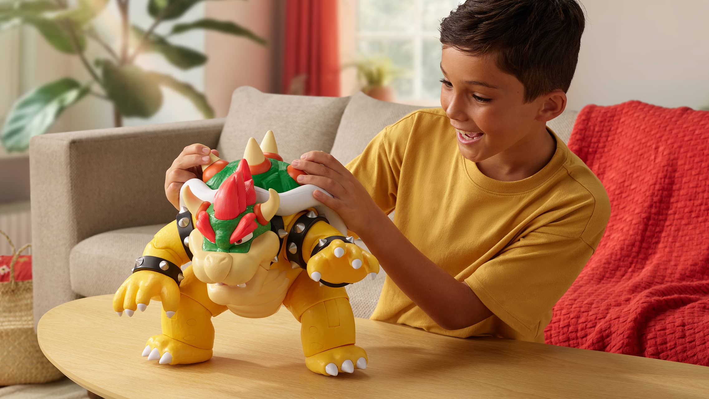 Child playing with large Bowser figure from Super Mario toy line