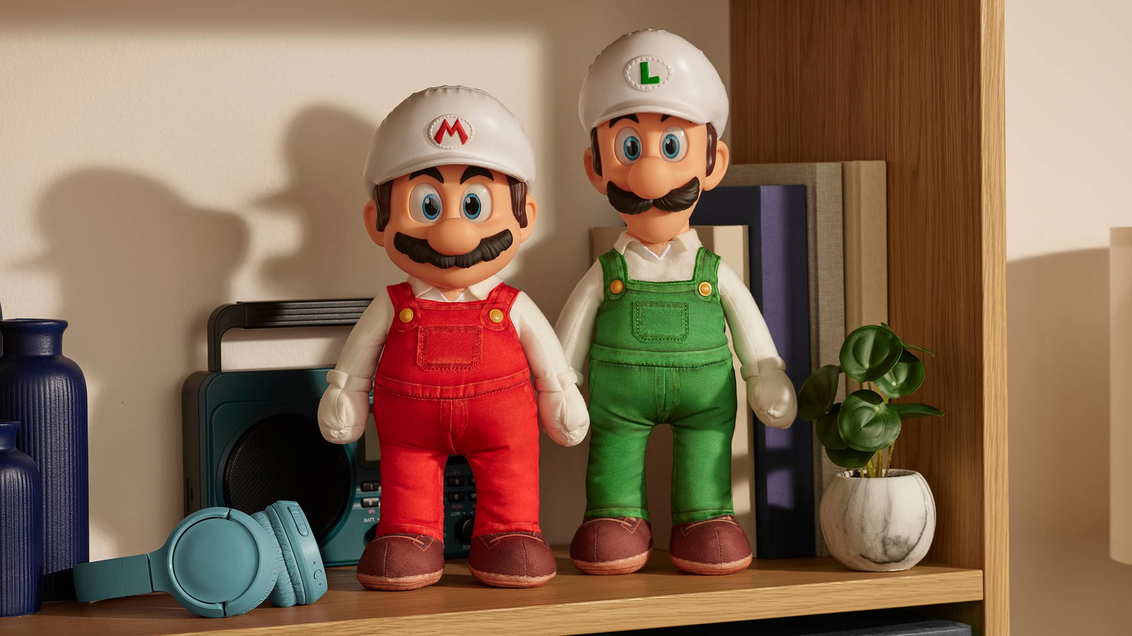 Super Mario and Luigi plush toys displayed on a shelf with home decor