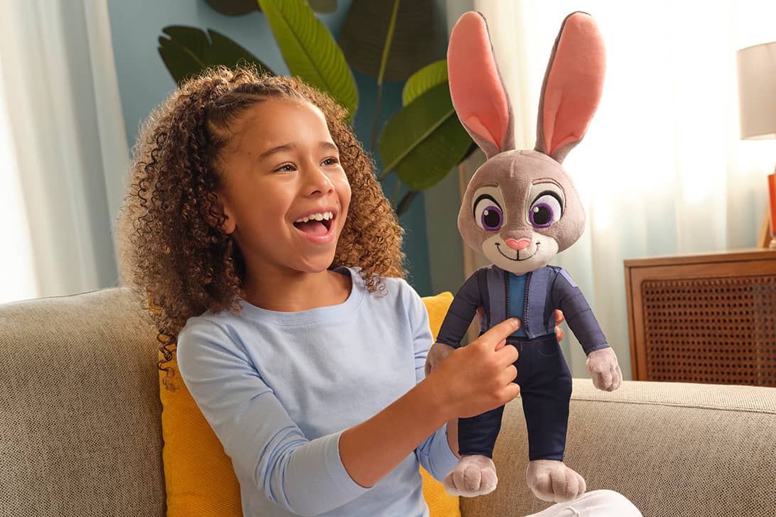 Child holding large Judy Hopps plush toy from Zootopia