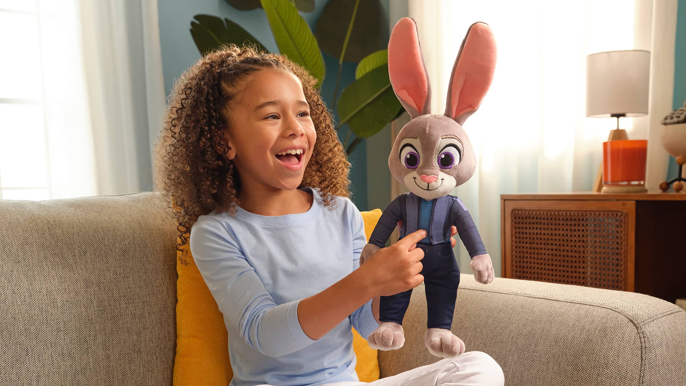 Child holding large Judy Hopps plush toy from Zootopia
