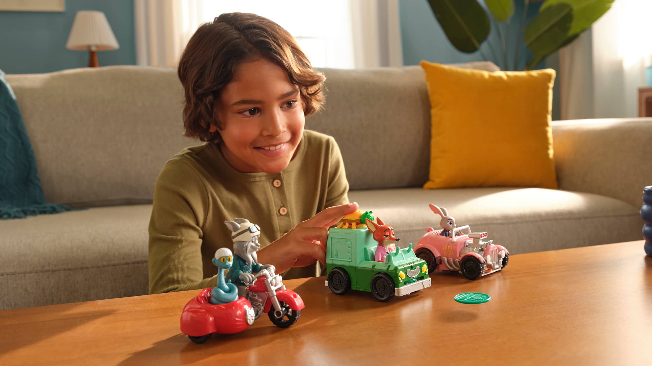 Child playing with Zootopia toy vehicles featuring Nick Wilde and Judy Hopps characters