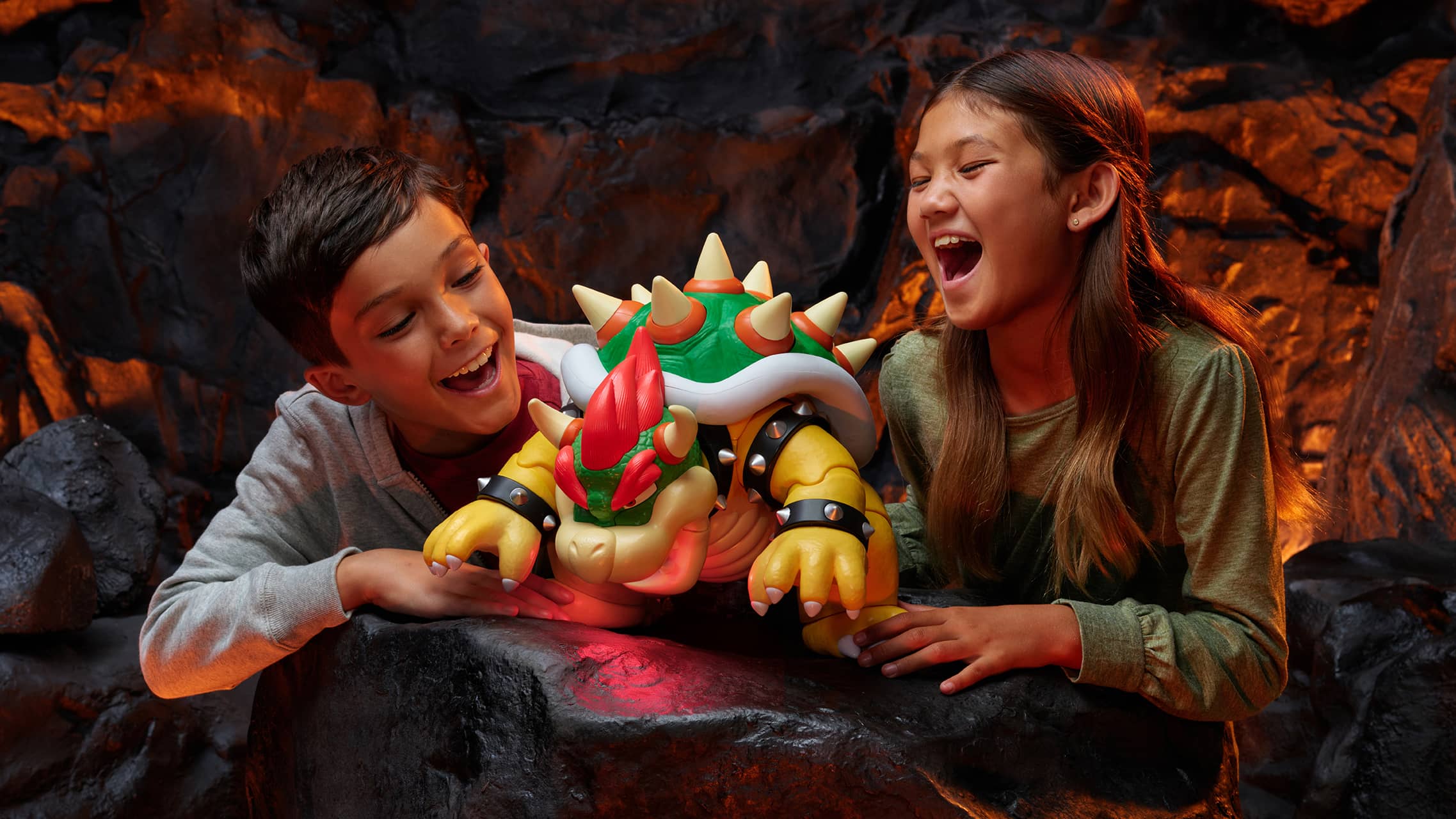 Kids playing with Bowser action figure from Super Mario in lava themed environment