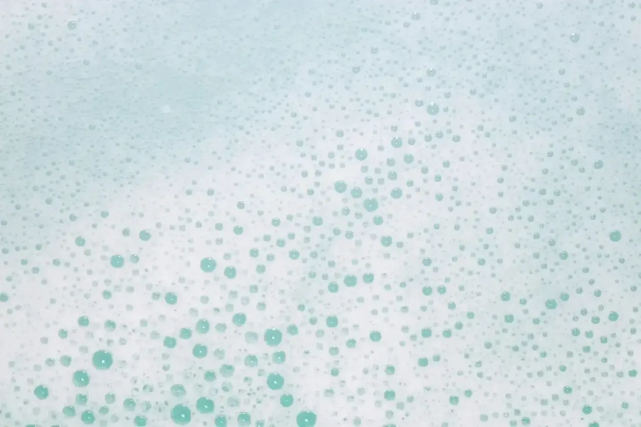 Nærbillede af masser af små blå bobler på en lyseblå overflade.