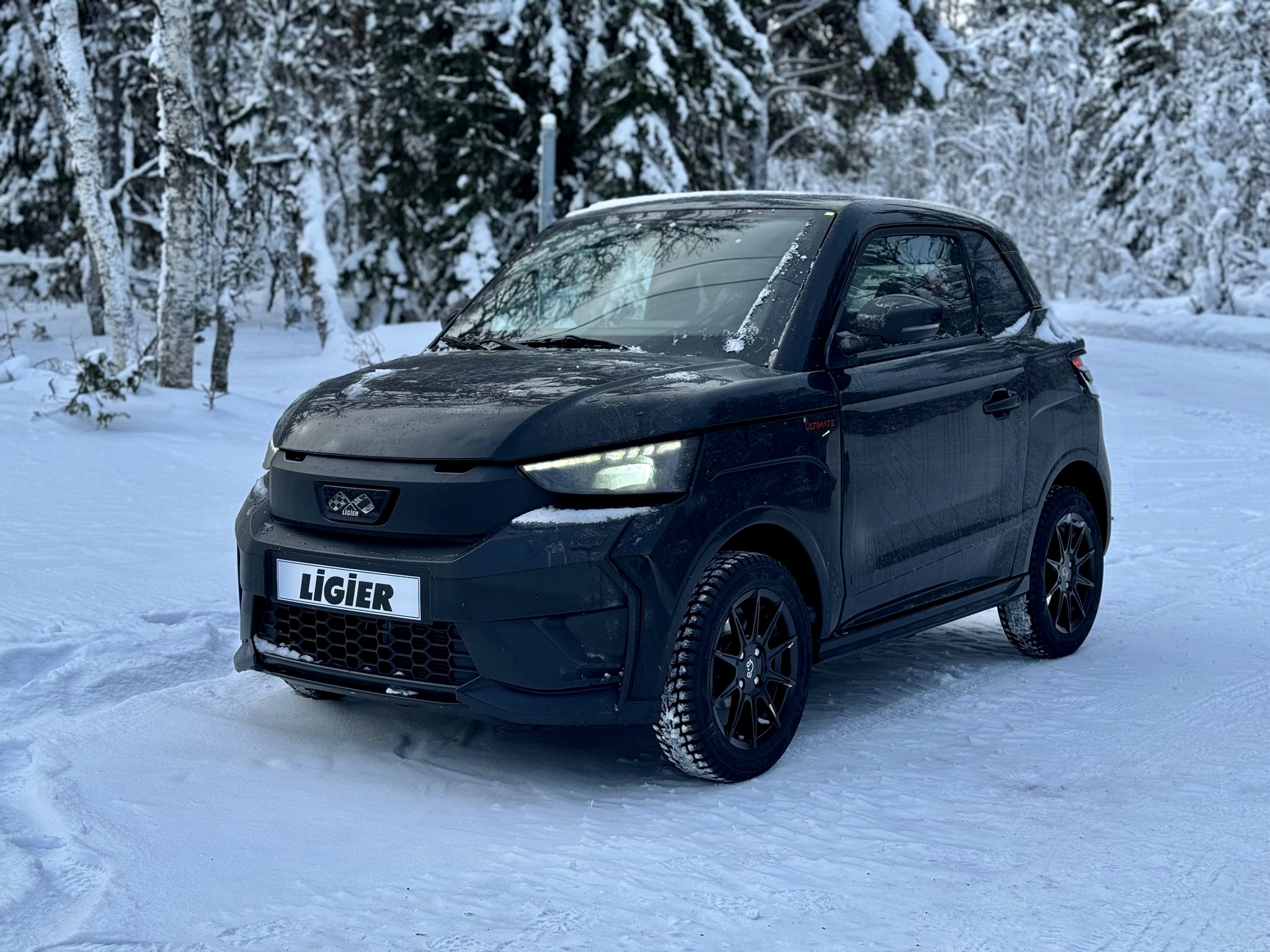 Sort Ligier JS50 på vinterhjul i snødekt skog