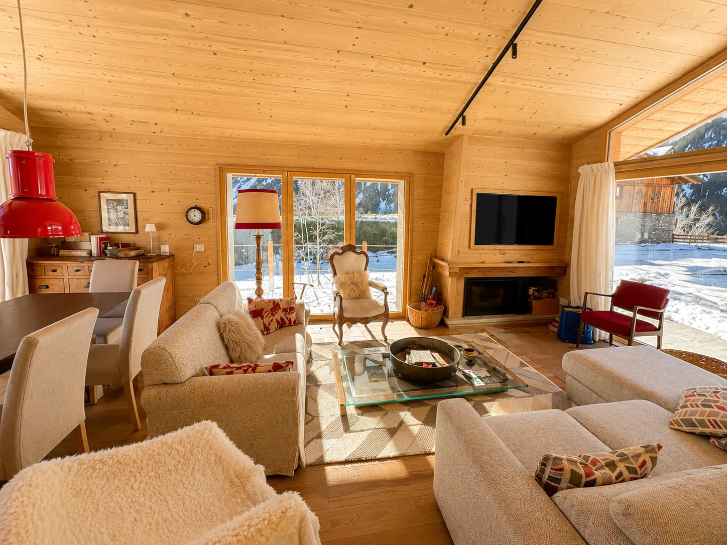 Chalet-Wohnzimmer mit Kamin und Blick auf verschneite Berge