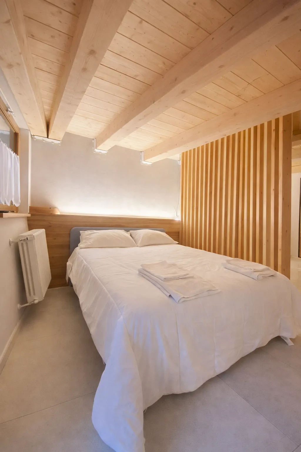 Schlafzimmer mit Holzdecke in einer von Imoreo betreuten Ferienwohnung in Courmayeur