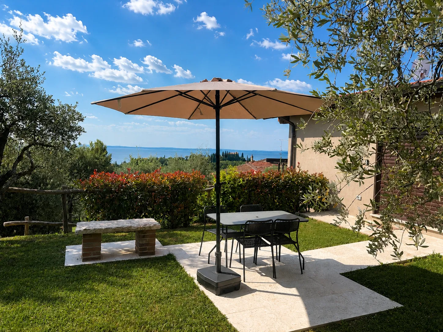 Terrasse mit Sonnenschirm und Blick auf den Gardasee