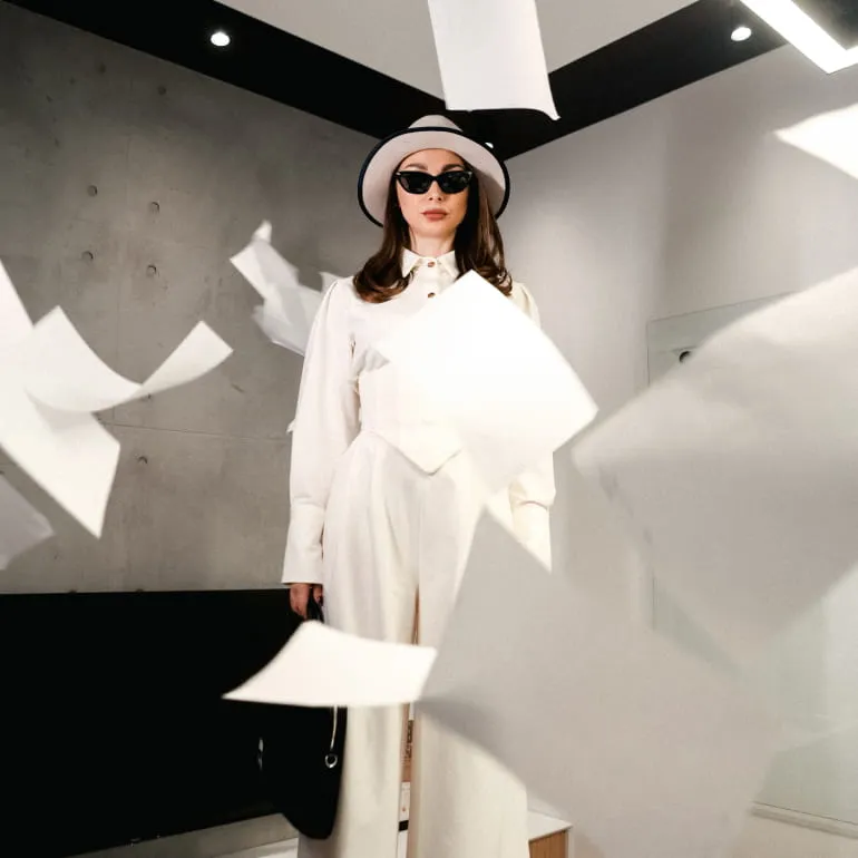 Two people working on laptops having a discussion in a modern office setting.