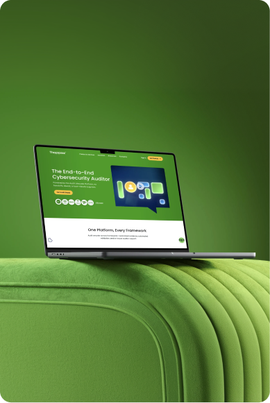 Laptop displaying a green-themed cybersecurity auditor platform screen, placed on a green textured surface.