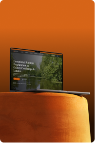 Laptop on an orange round pouf showing a website for exceptional summer programs in Oxford, Cambridge, and London.