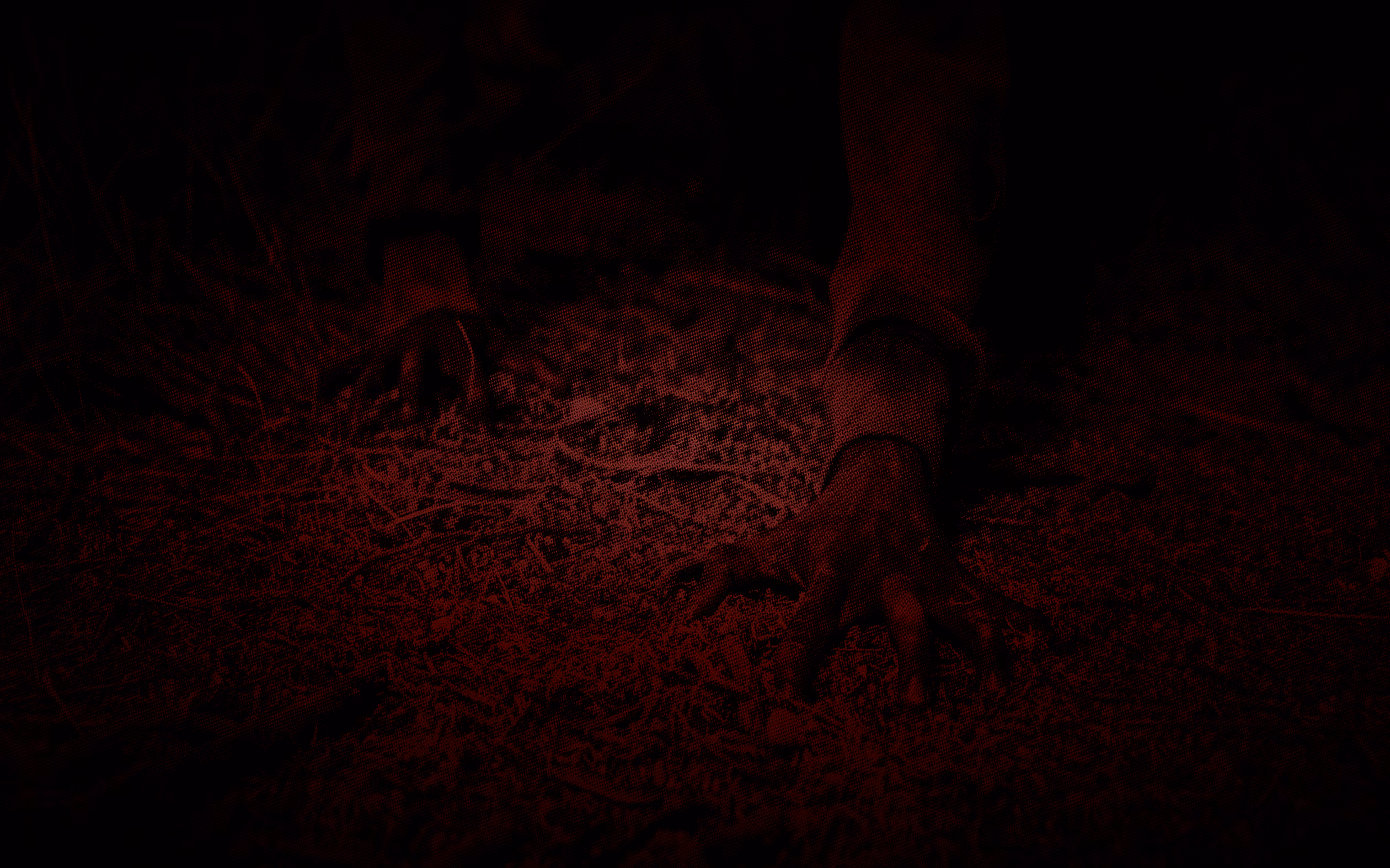 A hand reaching into dead leaves and twigs on the ground, lit in dark red horror-movie style