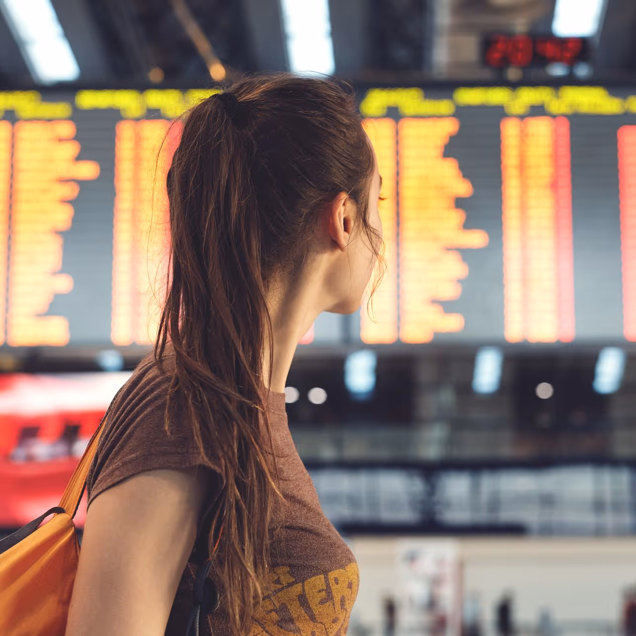 A woman looking at the airport schedule board