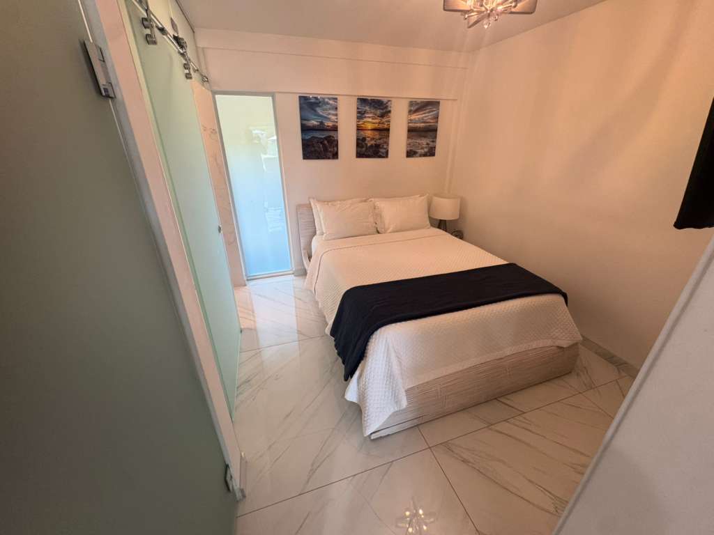 Bright bedroom with white bedding and navy accent in DGMI Cruz Bay luxury suite St. John.