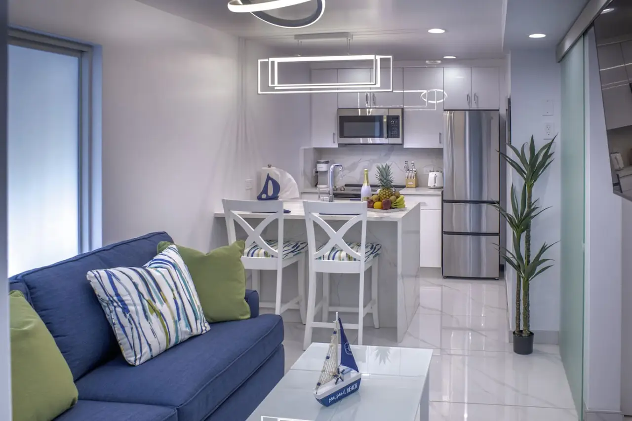 Modern open‑plan apartment interior with kitchen and sofa at DGMI Properties Cruz Bay St. John.