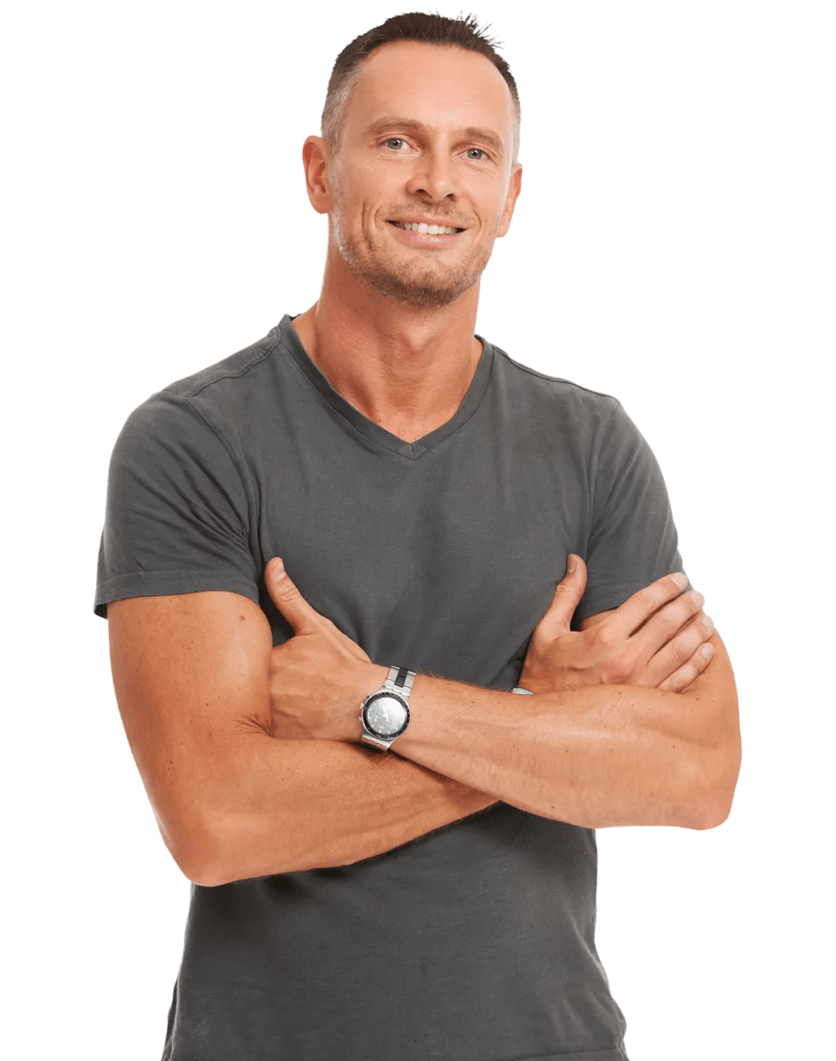 A fit, smiling man with short hair stands with his arms crossed, wearing a gray V-neck t-shirt and a wristwatch.