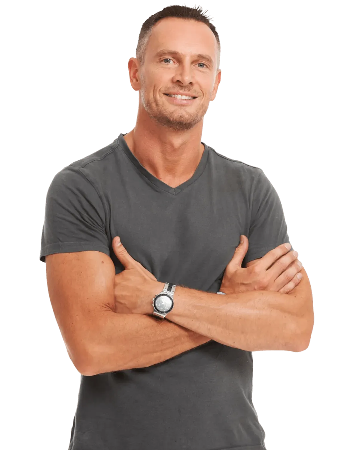 A fit, smiling man with short hair stands with his arms crossed, wearing a gray V-neck t-shirt and a wristwatch.