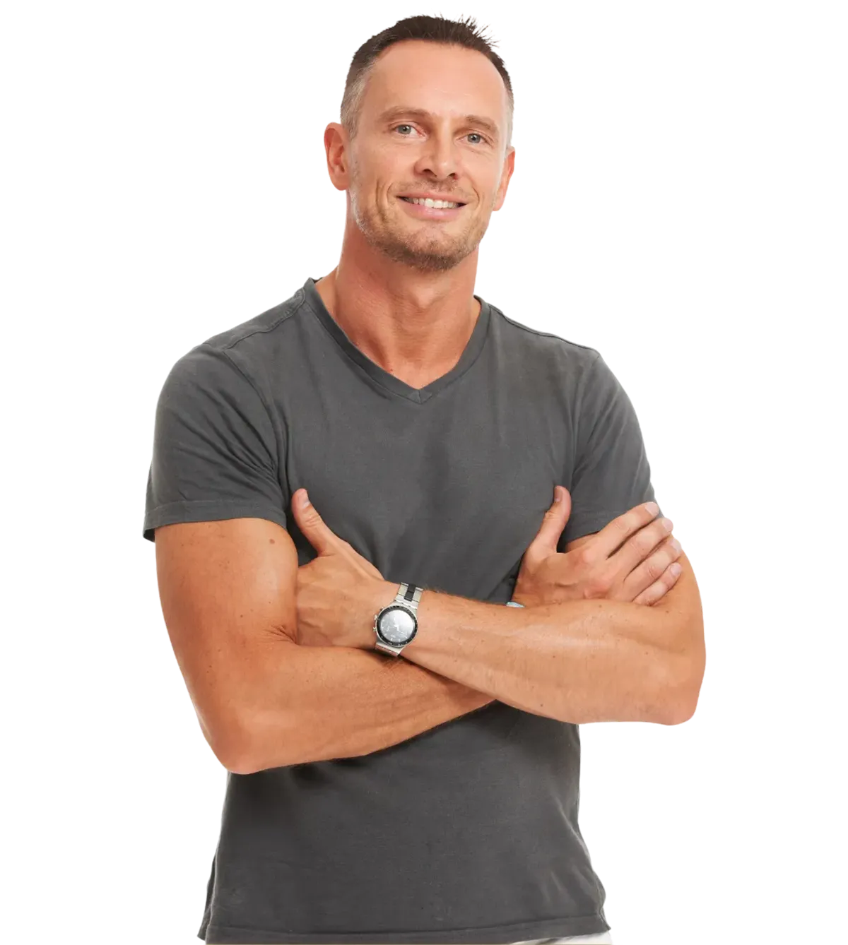 A smiling man with short dark hair wearing a teal t-shirt holds a kettlebell over his right shoulder against a plain white background.