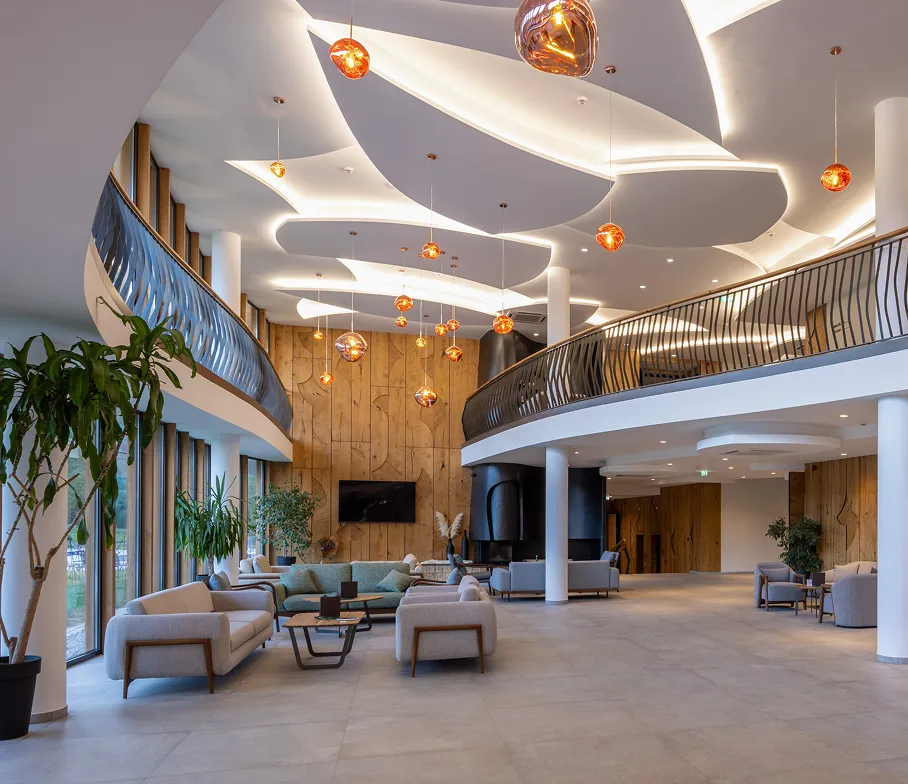Spacious modern lobby with sculptural ceiling lighting, lounge seating, and large windows.