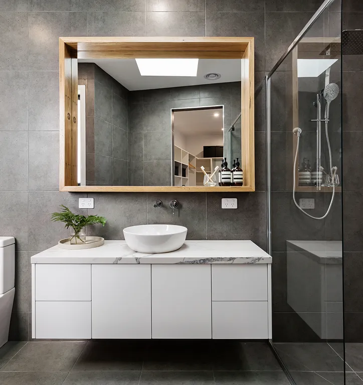 Contemporary bathroom renovation with floating vanity, vessel sink, and wood-framed mirror.