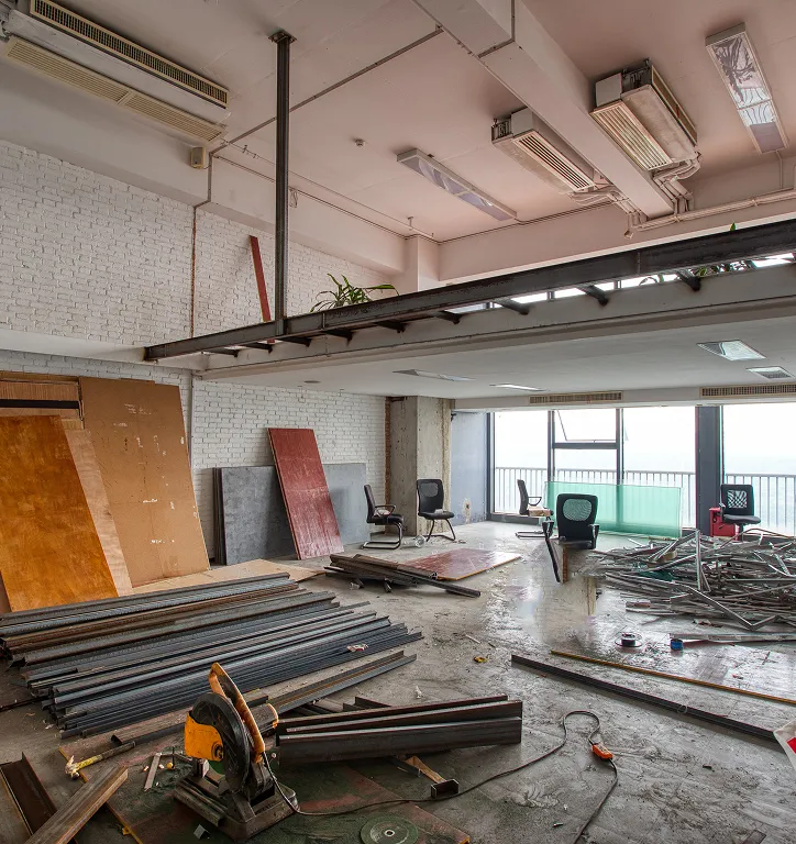 Interior space under renovation with metal beams, tools, and construction debris.