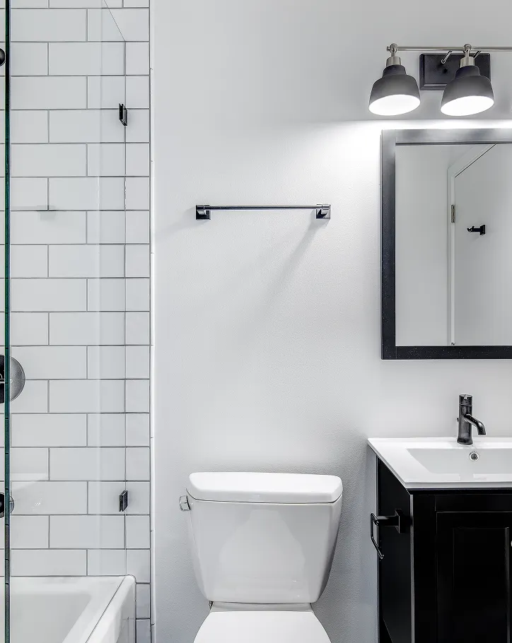 Updated black and white bathroom featuring subway tile shower and modern vanity.